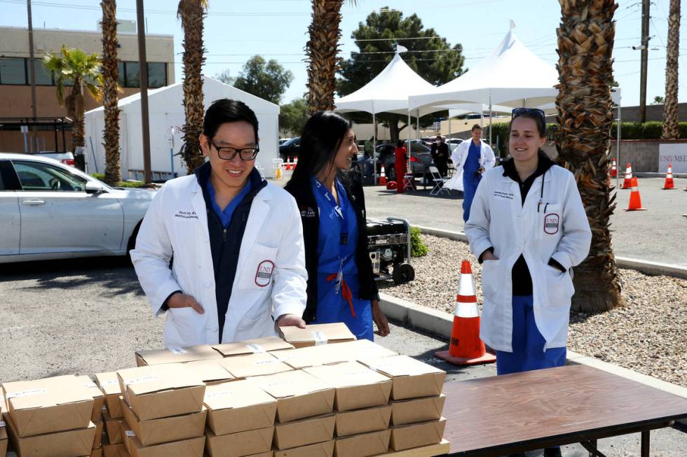 Drs. Kevin Tran, from left, Aradhana Mehta and Amanda Gracia grab box lunches provided by Sparr ...