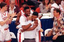 UNLV players Moses Scurry, left, and Anderson Hunt hug their coach Jerry Tarkanian after their ...
