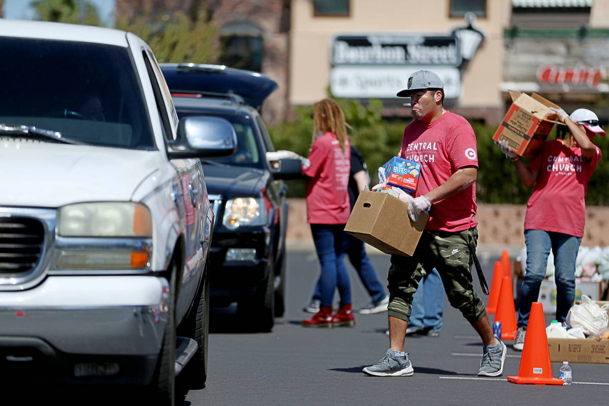 Volunteers for Three Square Food Bank give out food at Palace Station Casino in Las Vegas, Thur ...
