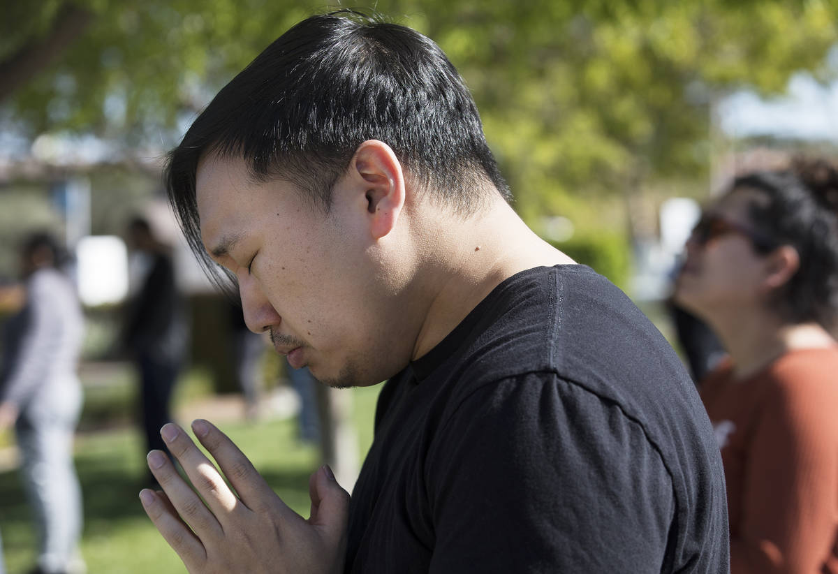 Paul Kim prays with family and friends for his friend Adriana Huh who is in the hospital with a ...