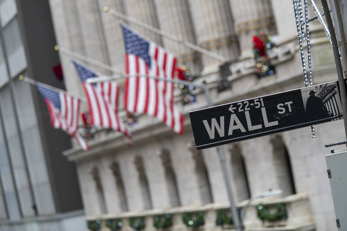 In a Jan. 3, 2020, file photo, the Wall St. street sign is framed by U.S. flags flying outside ...