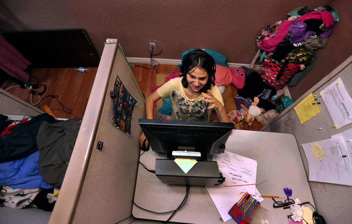 Aubrie Heenan, 17, left, plays Animal Crossing within her makeshift bedroom in a small office s ...