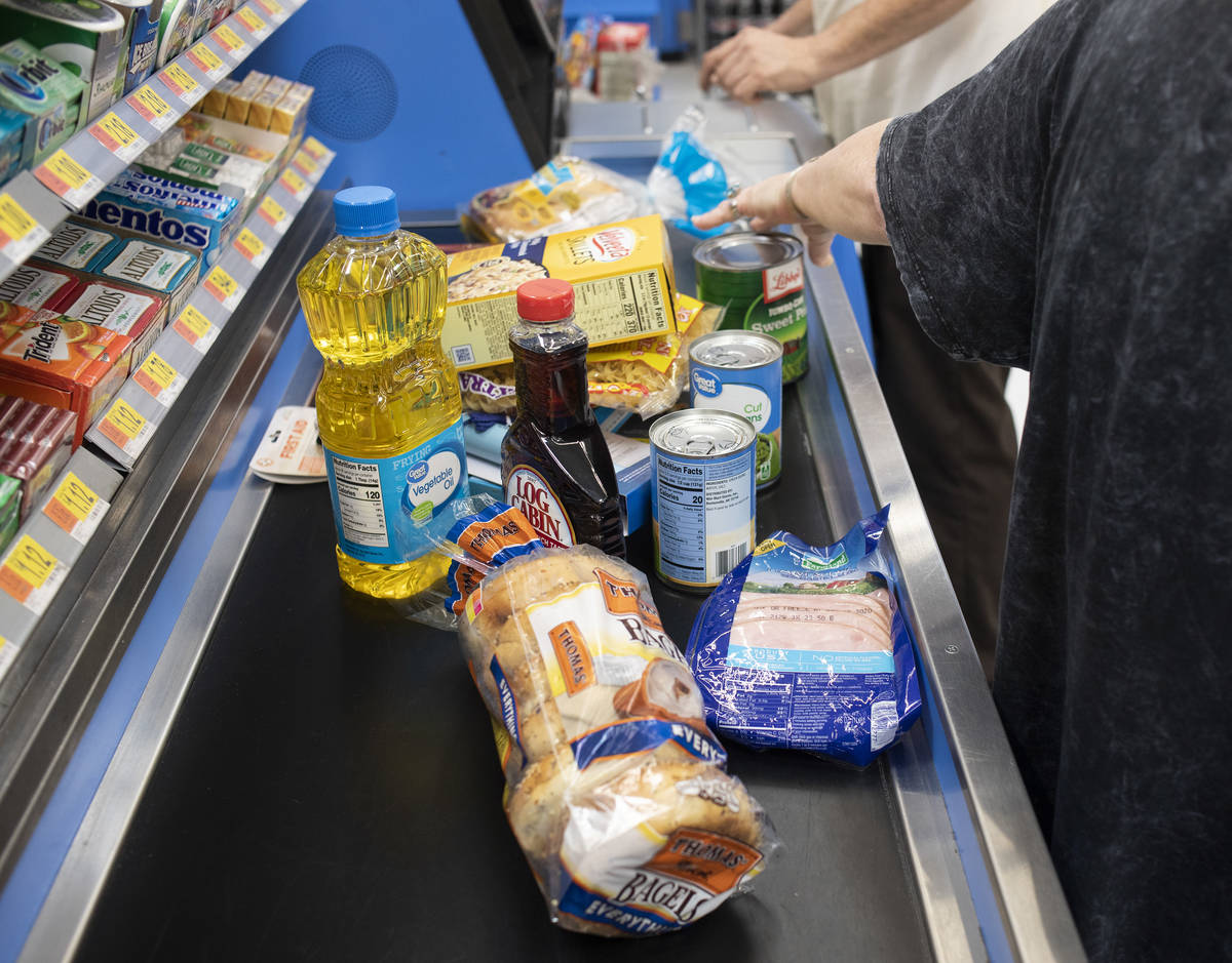 Debbie Holmgren unloads the cart as Todd Henke scans their haul from Walmart on Saturday, April ...