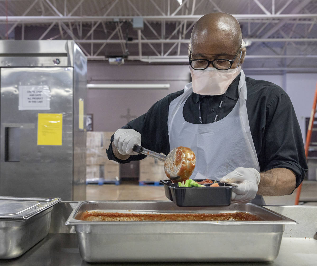 Frank Peoples helps package a dish for Meals on Wheels, at Catholic Charities of Southern Nevad ...