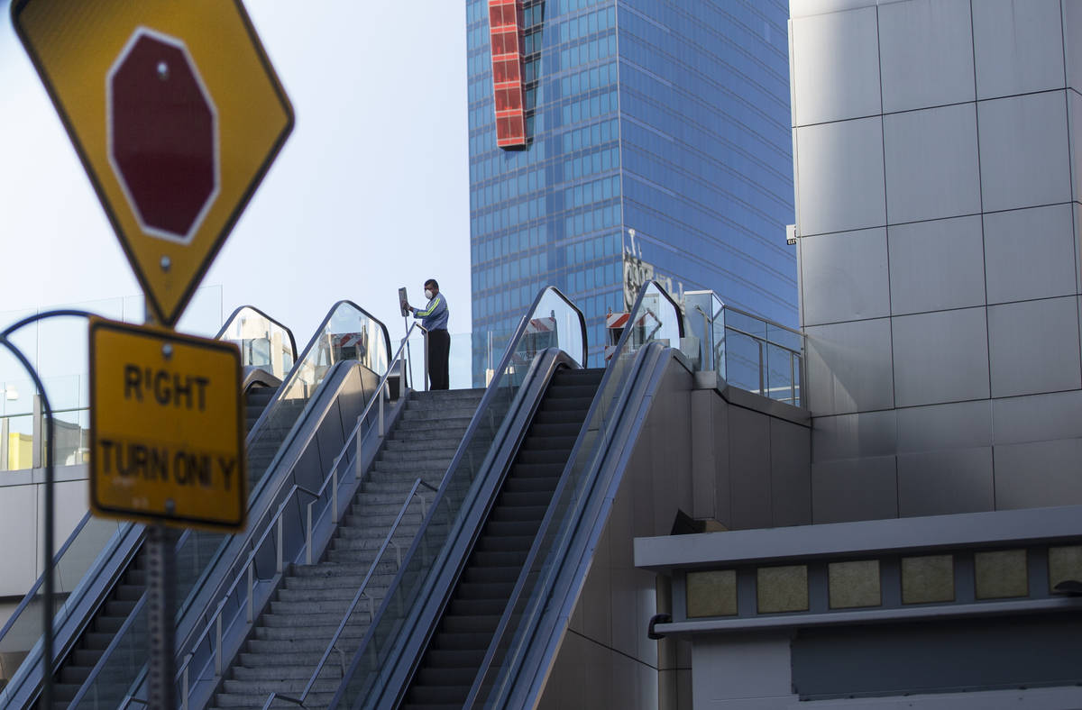 A worker sweeps a pedestrian walkway on the Strip on Saturday, April 4, 2020, in Las Vegas. (Be ...