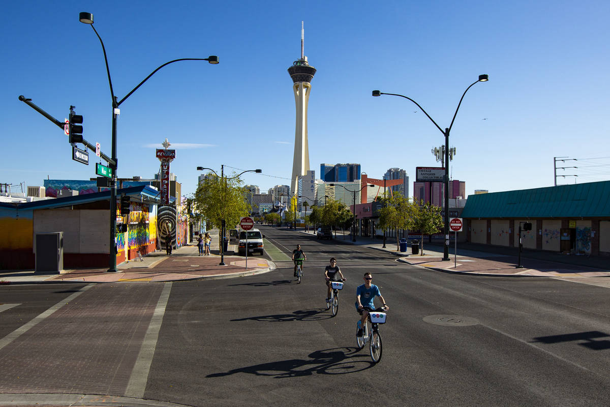 People bike down Main Street in the Arts District as traffic remains light in the wake of the c ...