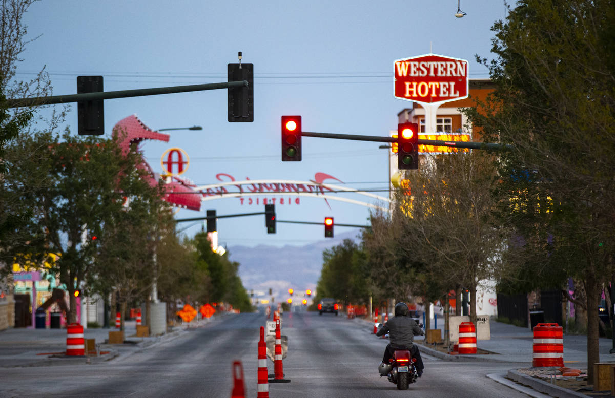 A man rides a motorcycle down Fremont Street as traffic remains light in the wake of the closur ...