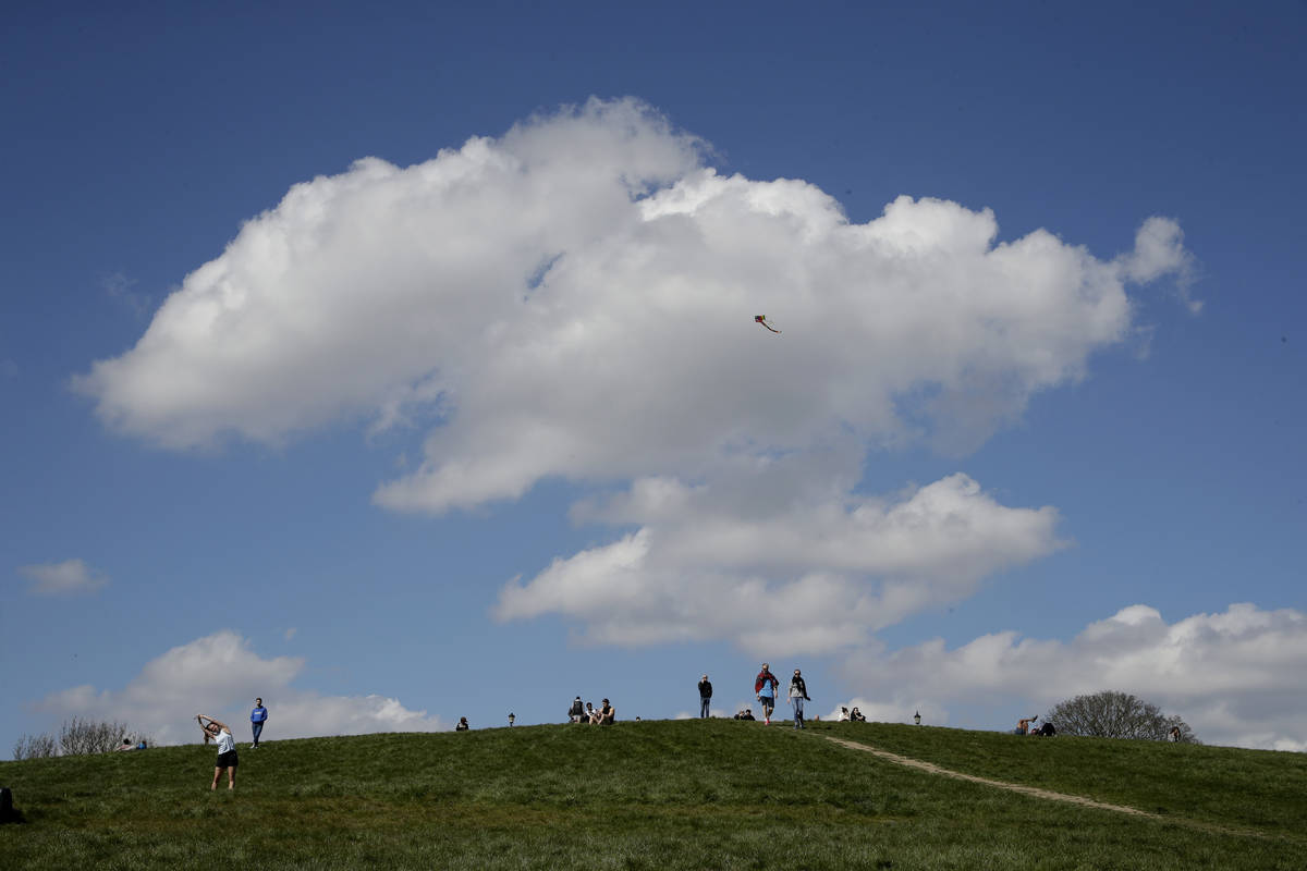 A kite is flown as people observe social distancing on Primrose Hill in London, as London's par ...