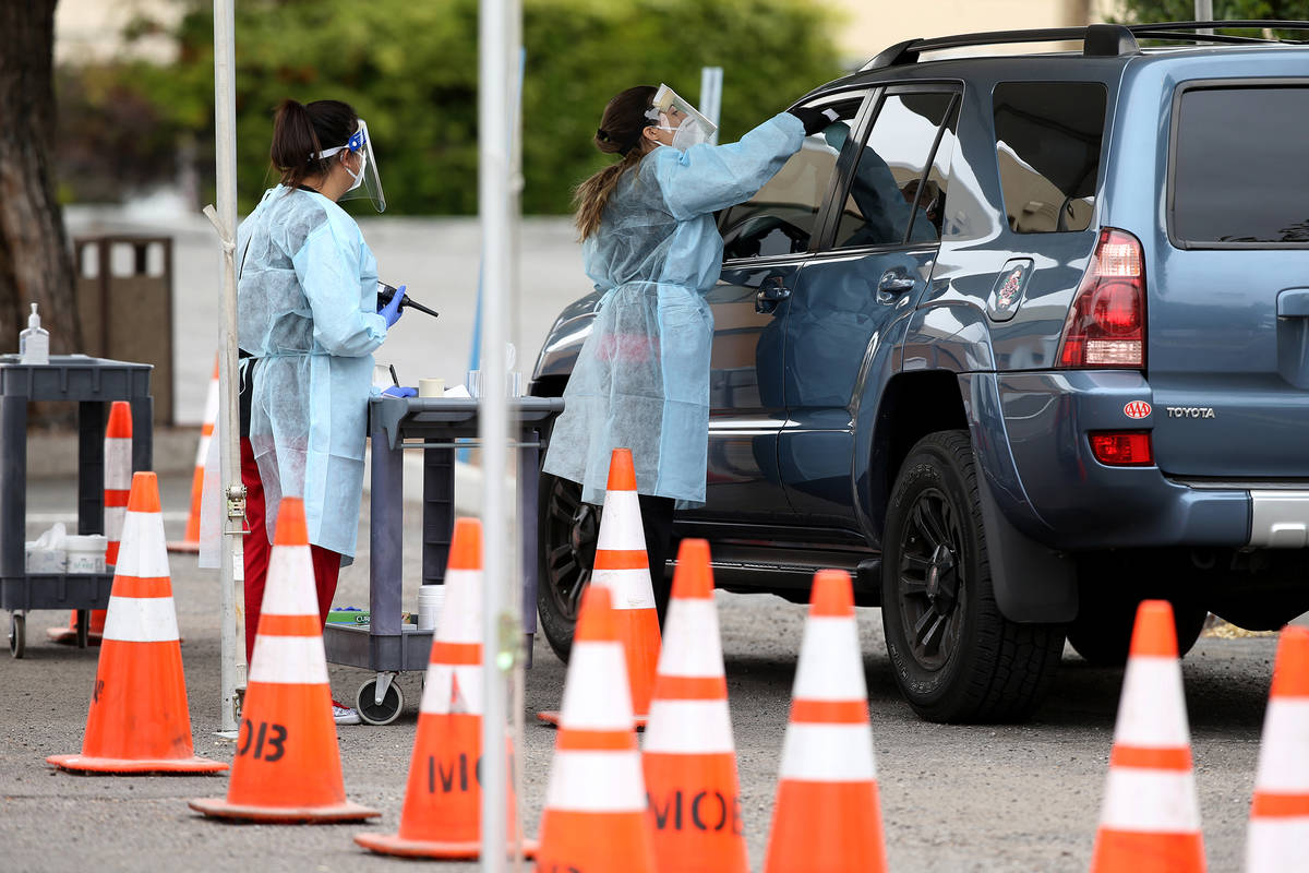 UNLV School of Medicine Certified Medical Assistants test curbside for COVID-19 at the school i ...