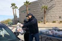 Clark County School District employees Miguel Zazueta, right, and Greggy Malimban help pass out ...