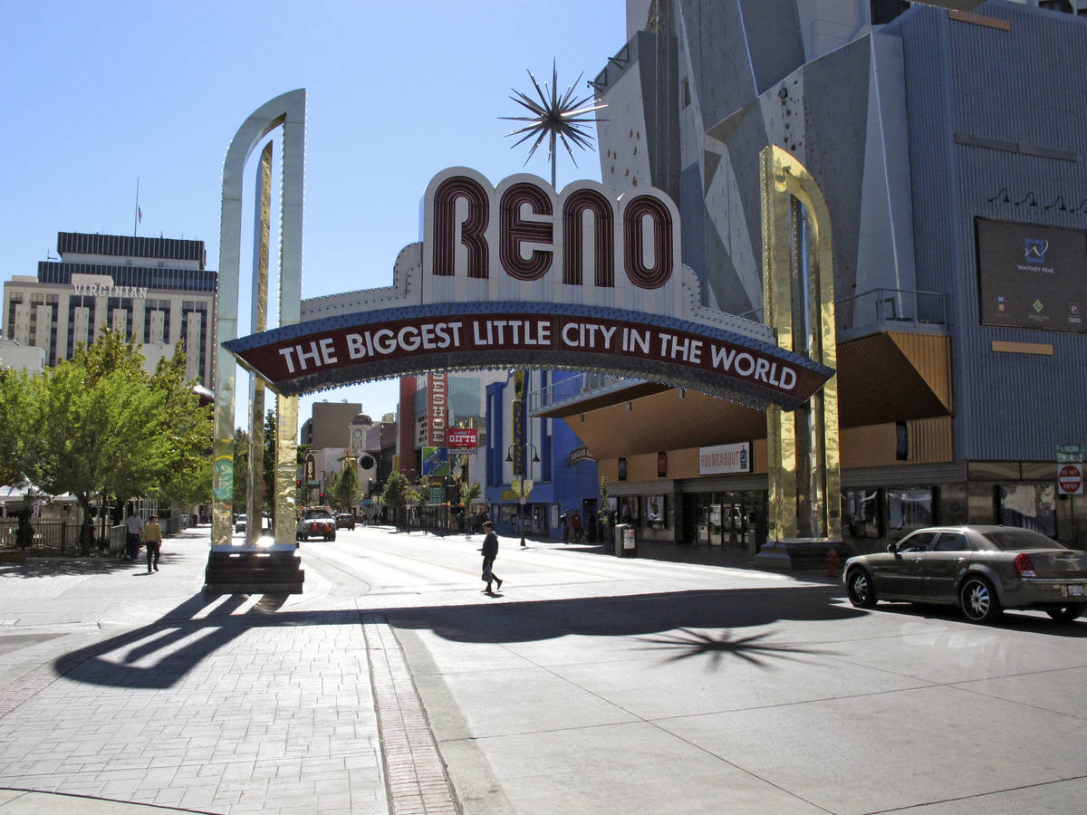In this Oct. 11, 2016, file photo, pedestrians pass beneath the Reno arch as traffic passes on ...