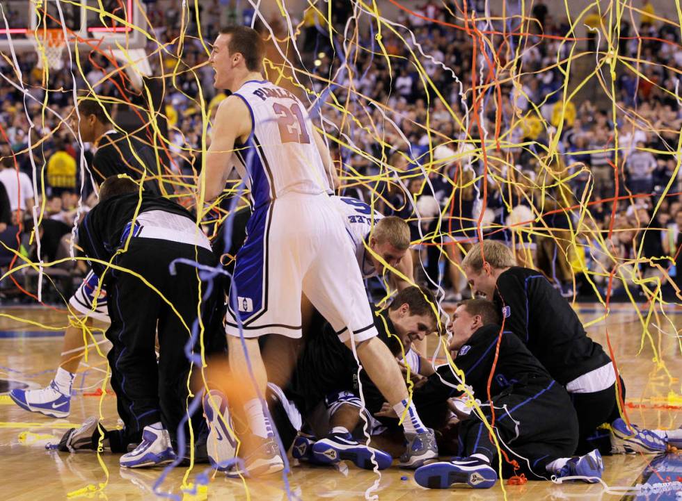 FILE - In this April 5, 2010, file photo, Duke's Miles Plumlee (21) and teammates celebrate aft ...