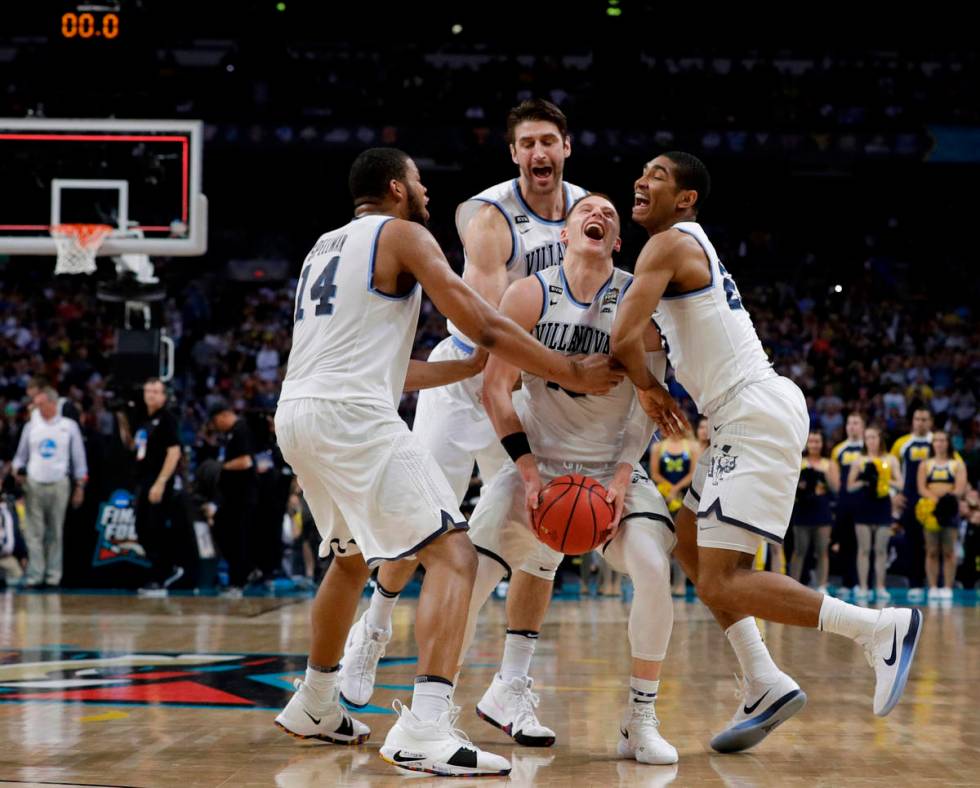 Villanova guard Donte DiVincenzo, center, celebrates with teammates at the end of the champions ...