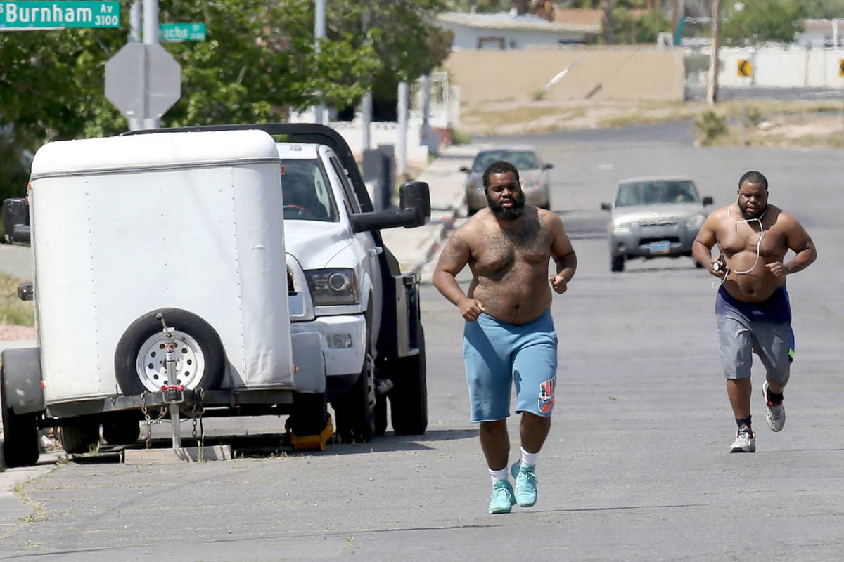 Martinn Solomon, 27, and his brother Marcell Solomon, 32, jog on Golden Arrow Drive near Burnha ...
