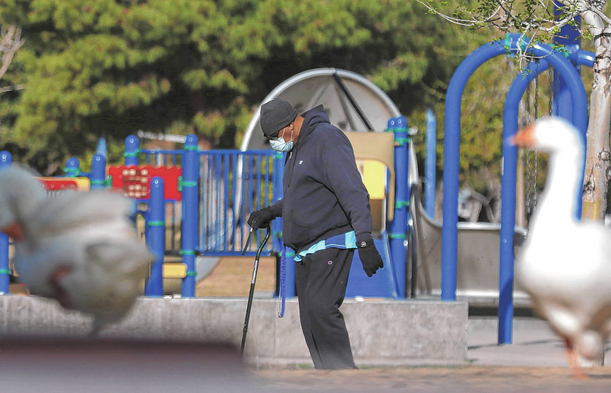 A man, who declined to give his name, wears protective masks as he walks at Sunset Park on Wedn ...