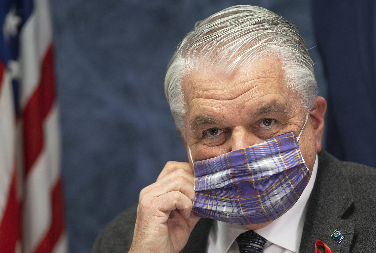Gov. Steve Sisolak wears a protective mask before the start of a press conference to update Nev ...