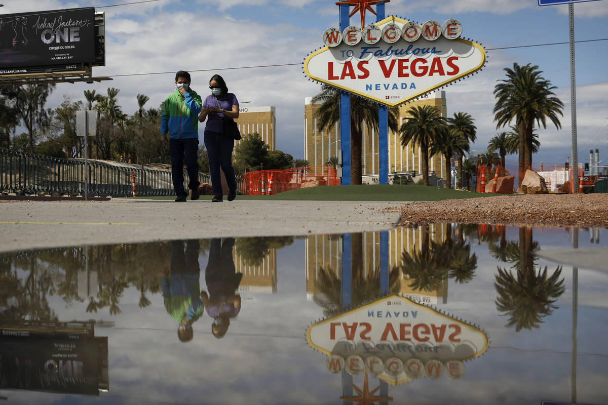 People wearing face masks visit the usually crowded "Welcome to Fabulous Las Vegas Nevada& ...