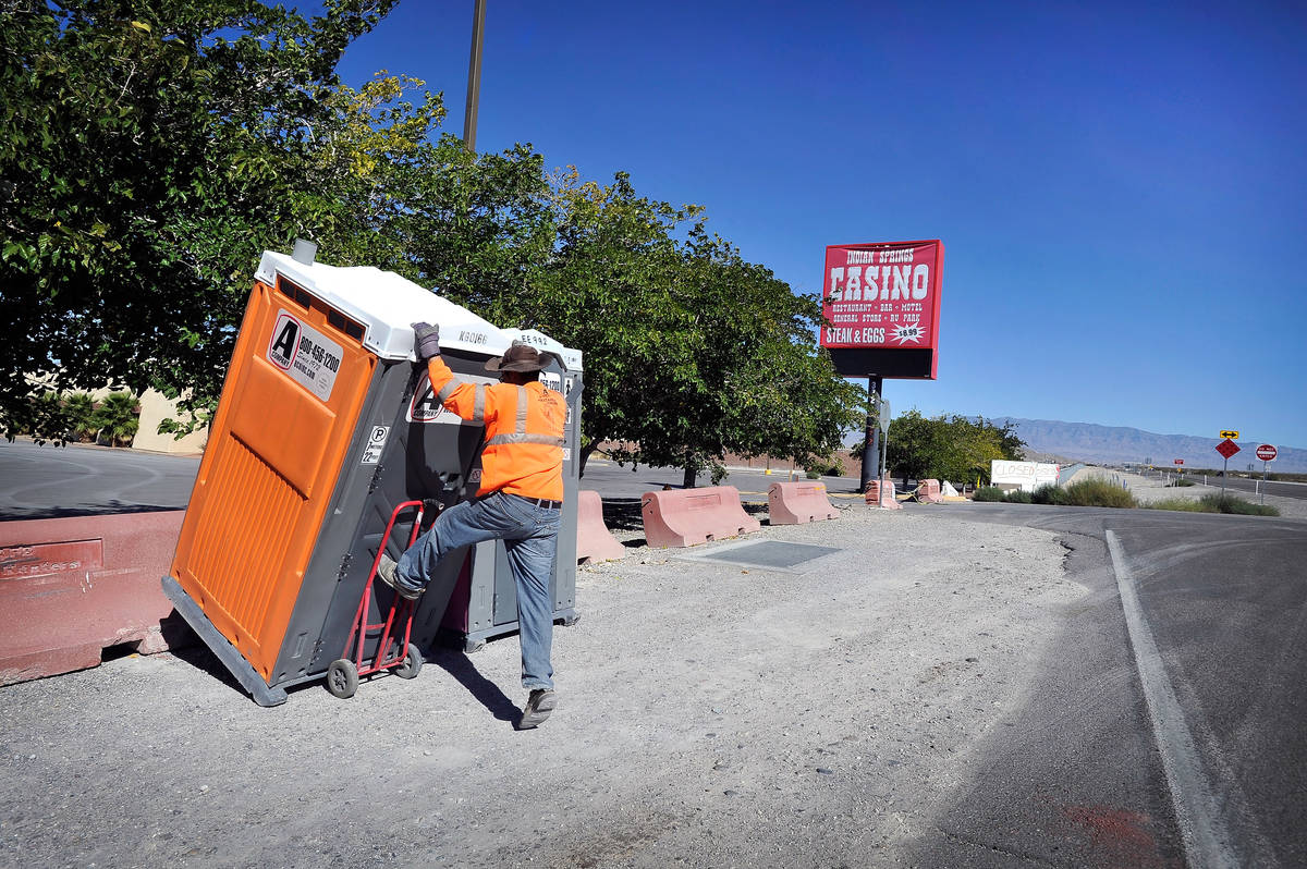 Louis Fuentes loads a portable toilet that was temporarily stored in front of the now closed In ...