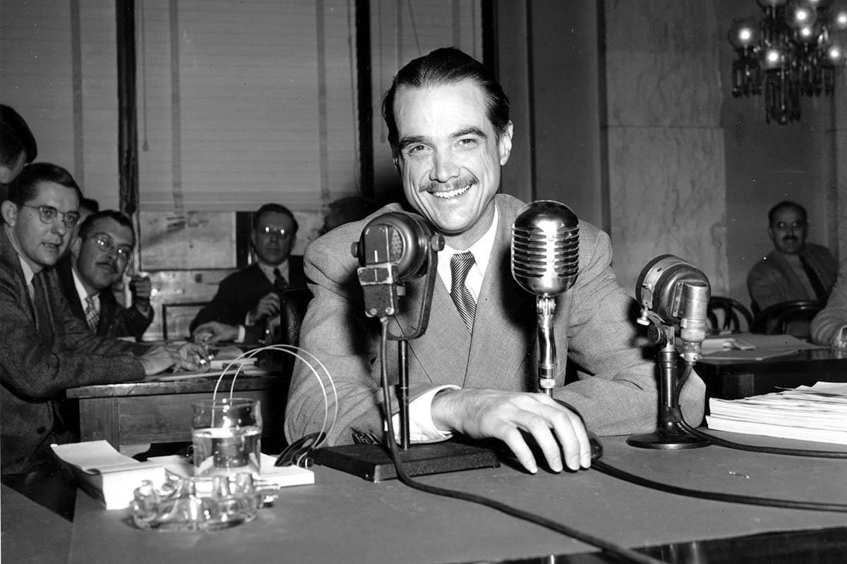 In this Nov. 15, 1947, file photo, Howard Hughes smiles as he sits in the witness chair before ...