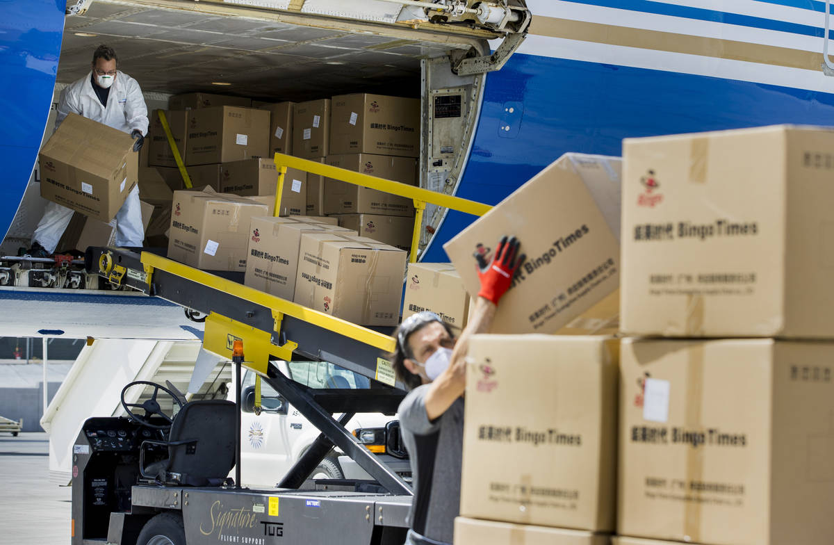Transport workers unload some of the 1 million surgical masks arriving from Guangzhou, China, a ...