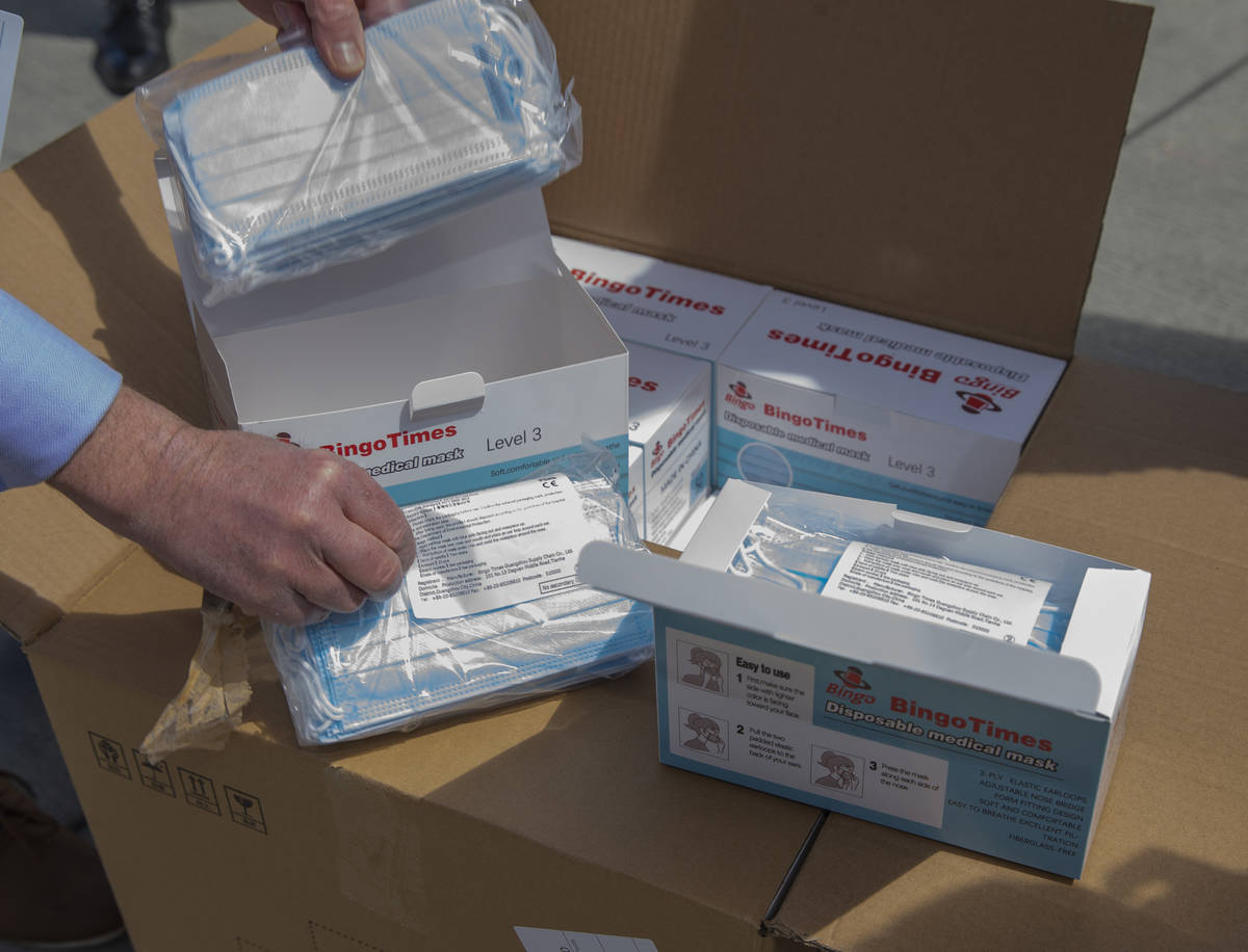 The first box is cracked open to reveal a few of the 1 million surgical masks arriving from Gua ...