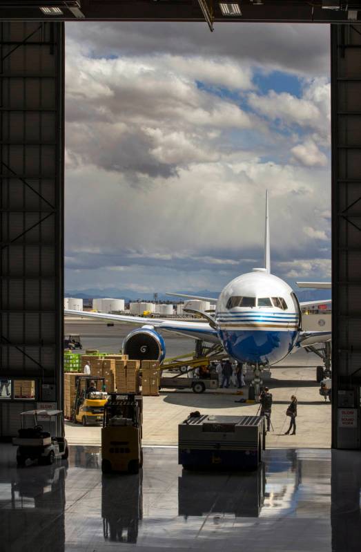 Transport workers unload some of the 1 million surgical masks arriving from Guangzhou, China, a ...