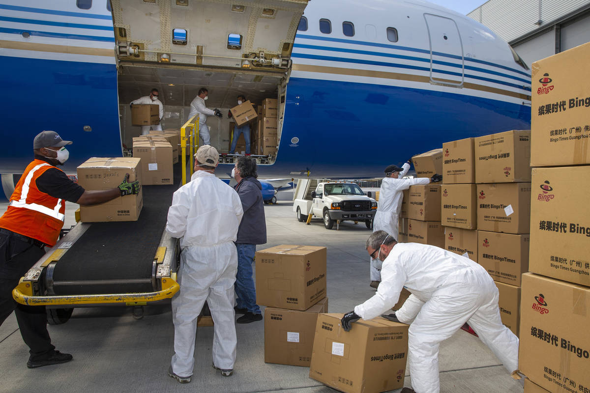 Transport workers unload some of the 1 million surgical masks arriving from Guangzhou, China, a ...