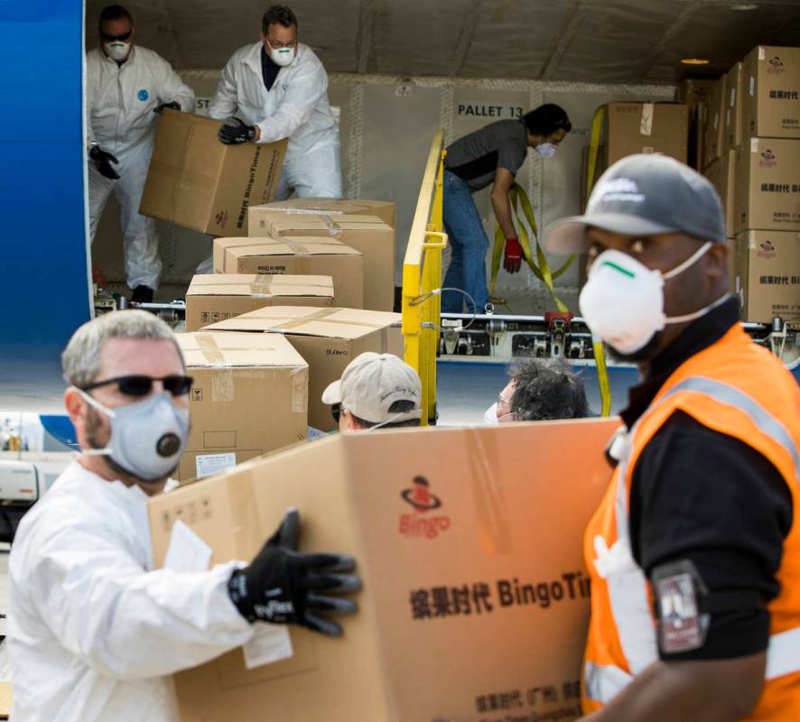 Transport workers unload some of the 1 million surgical masks arriving from Guangzhou, China, a ...