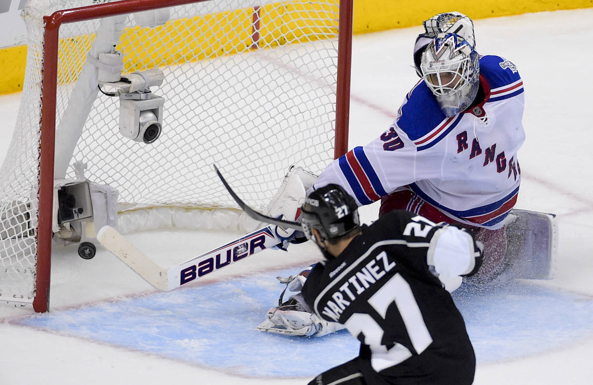 Los Angeles Kings defenseman Alec Martinez, left, scores the winning goal past New York Rangers ...