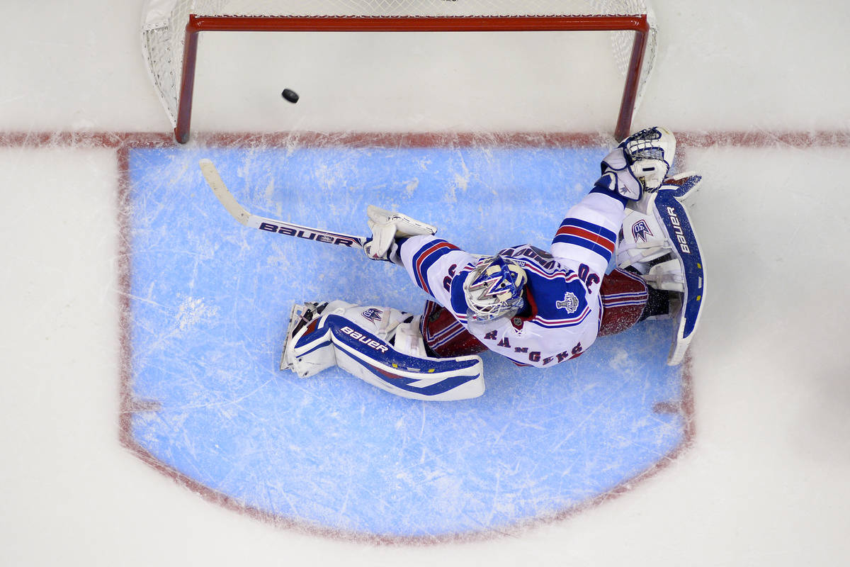 New York Rangers goalie Henrik Lundqvist, of Sweden, is scored on by Los Angeles Kings defensem ...