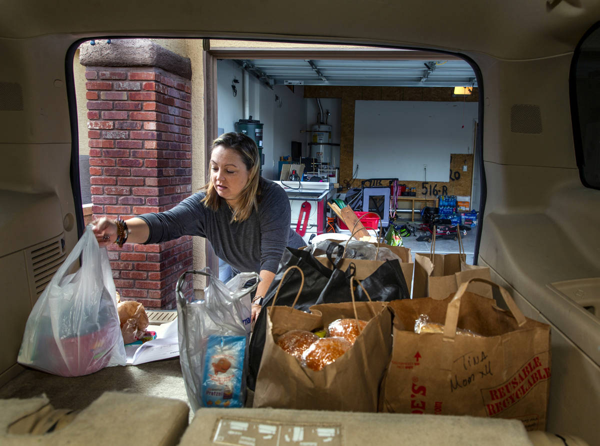 Kat Morris fills the back of her car with food and supplies for another donation drop with the ...
