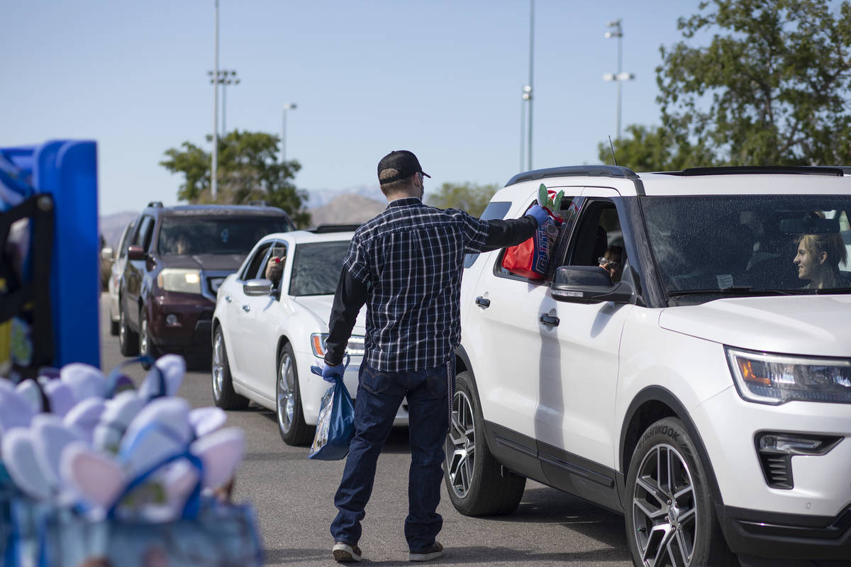 Volunteers hand out Easter baskets in a drive through procession at Mountain Ridge Park on Satu ...