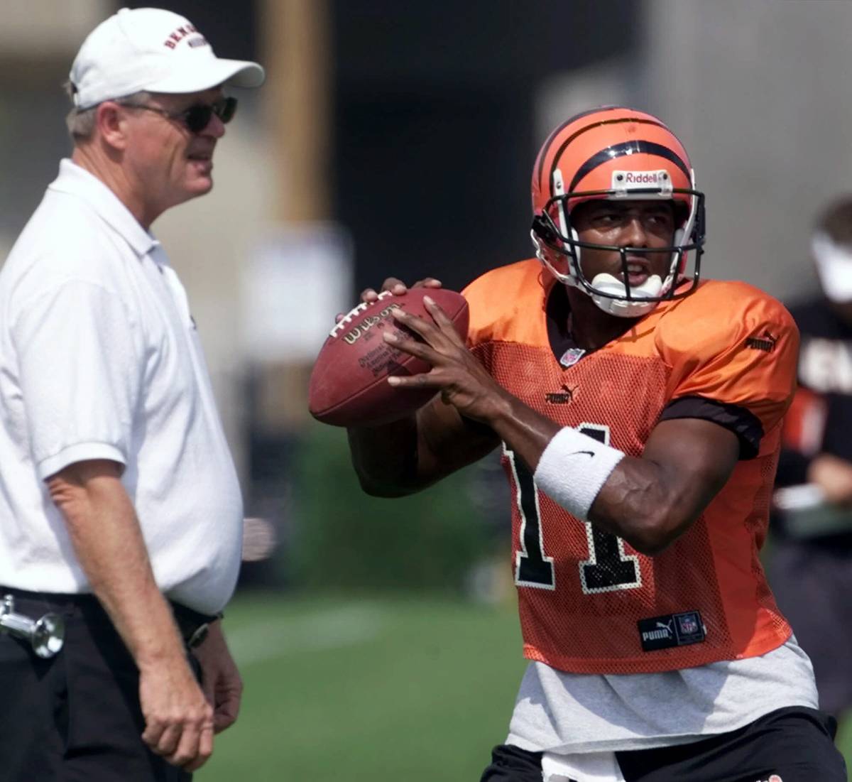Cincinnati Bengals quarterback Akili Smith (11) sets to throw a pass as head coach Bruce Coslet ...