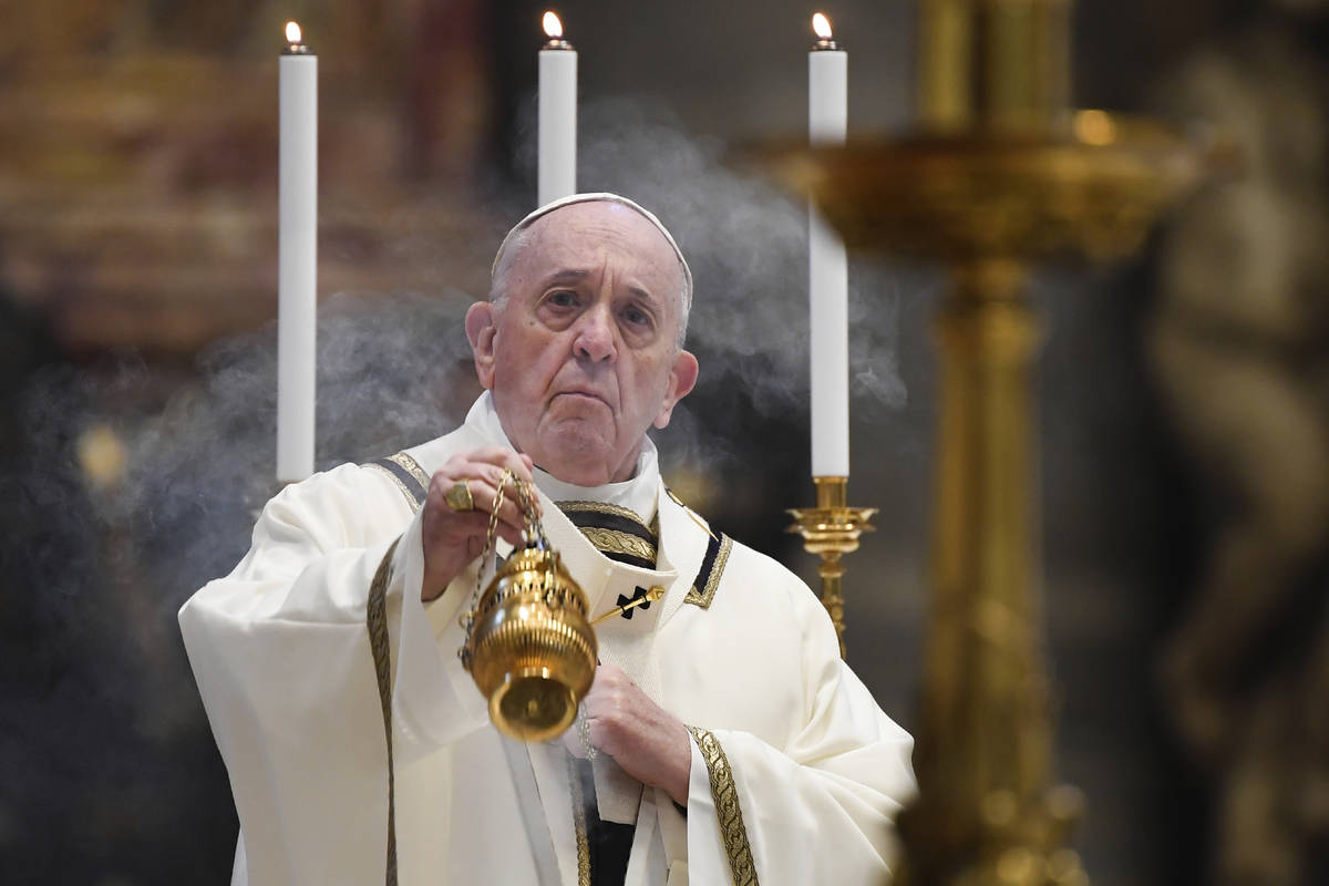 Pope Francis spreads incense at the start of Easter Sunday Mass, inside an empty St. Peter's Ba ...