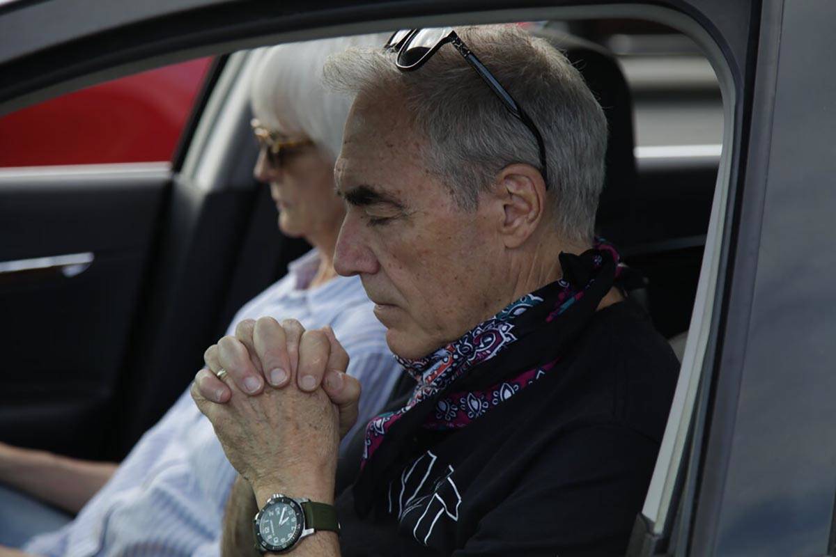 Terry Sartain prays inside his car during Relevant Church's Easter service at a YMCA parking lo ...
