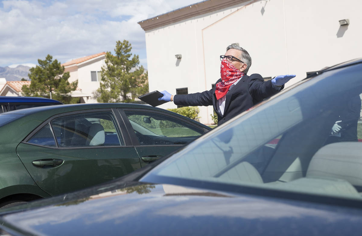 Pastor Paul Marc Goulet walks among cars as he leads an Easter service in the parking lot at In ...