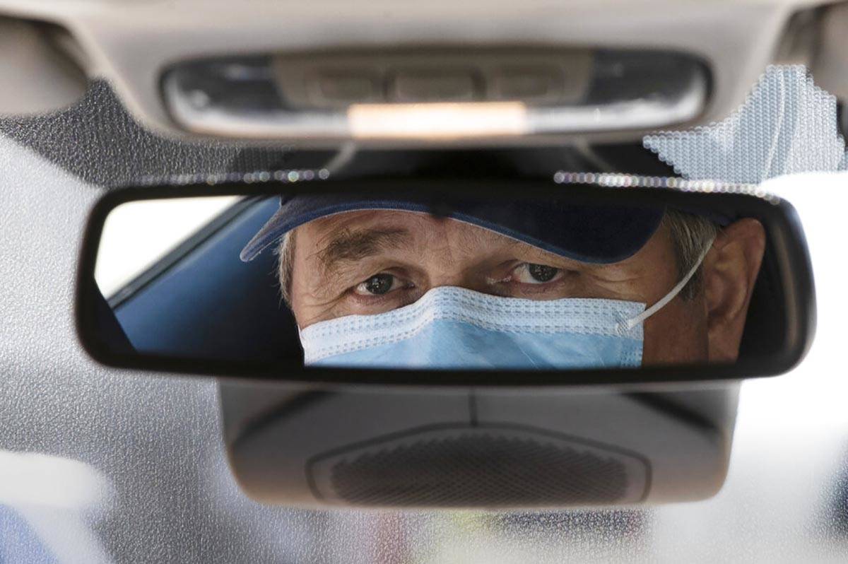 Taxi driver Nicolae Hent, wearing a protective mask, poses for a photograph before before start ...
