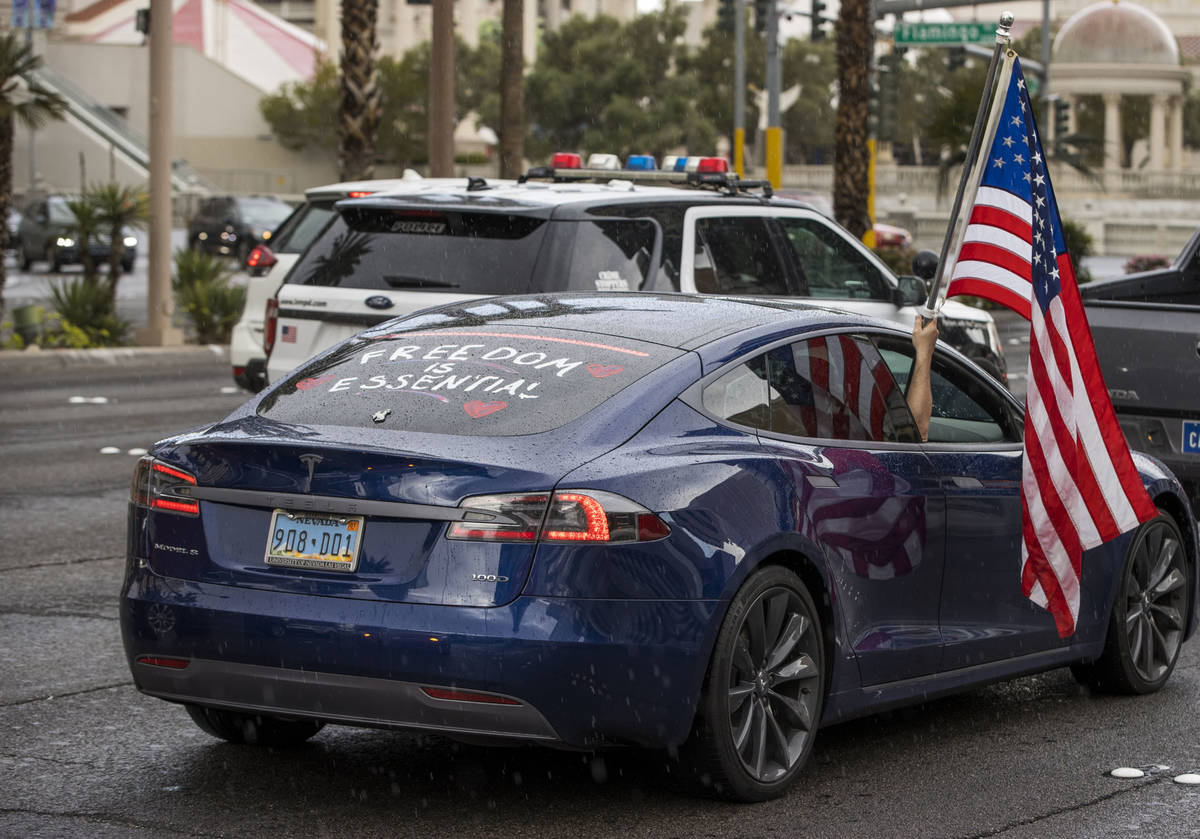 Some participants fly American flags as vehicles make their way up the Las Vegas Strip during t ...
