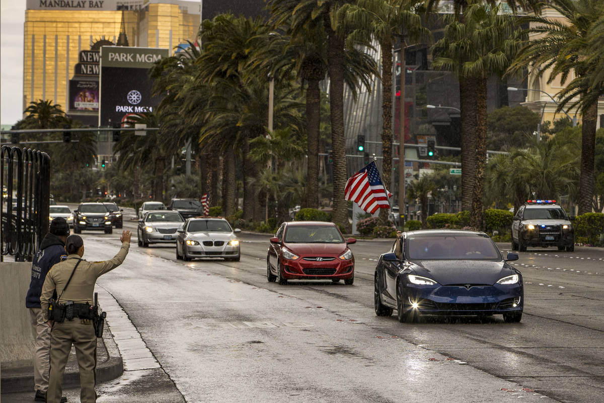 Some participants fly American flags as vehicles make their way up the Las Vegas Strip during t ...