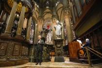 Italian singer Andrea Bocelli, left, performs inside an empty Duomo cathedral, on Easter Sunday ...