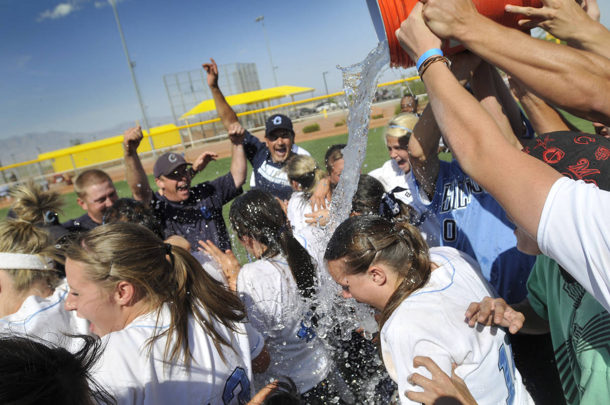 Centennial High School softball team members get doused with ice water by fans as the celebrate ...