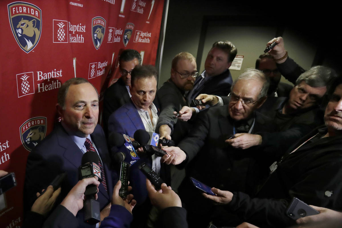National Hockey League Commissioner Gary Bettman, left, speaks to members of the media , Saturd ...
