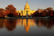 The US Capitol is bathed in the setting sun and seen in the reflecting pool on Capitol Hill in ...