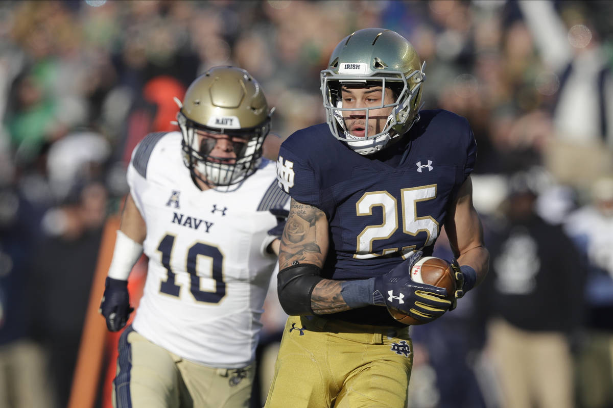 Notre Dame wide receiver Braden Lenzy (25) runs for a touchdown against Navy safety Kevin Brenn ...