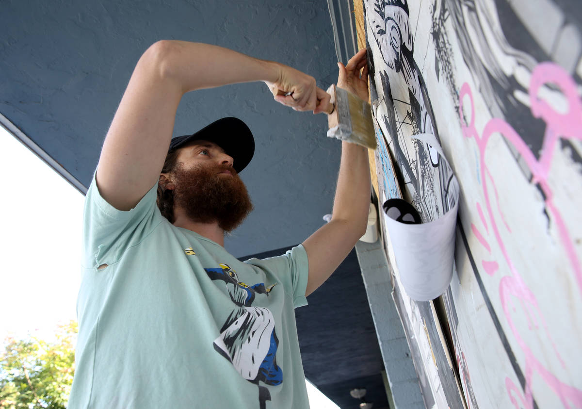 Artist Izaac Zevalking (aka: Recycled Propaganda) creates art on boards covering windows at his ...