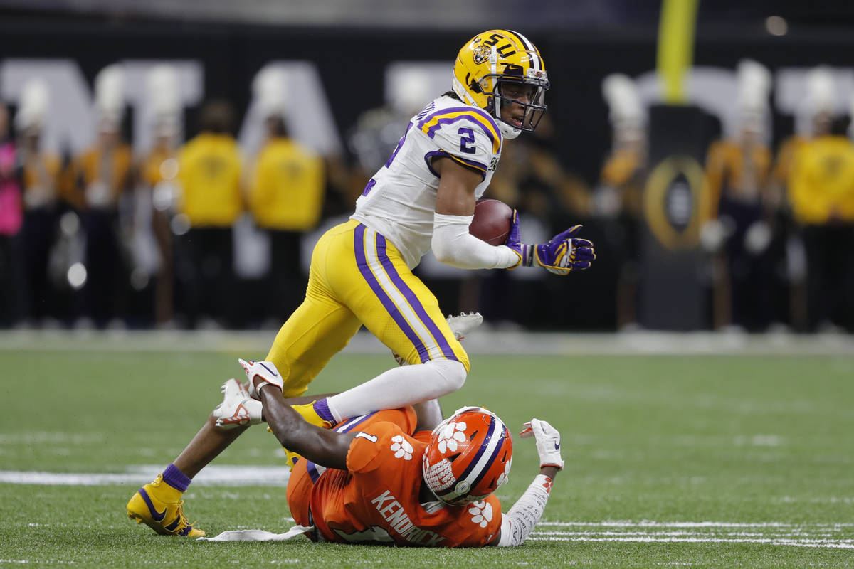 LSU wide receiver Justin Jefferson runs over Clemson cornerback Derion Kendrick during the firs ...