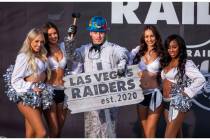 Painter Angel Ayala poses with a hammer between the Raiderettes during a special announcement a ...