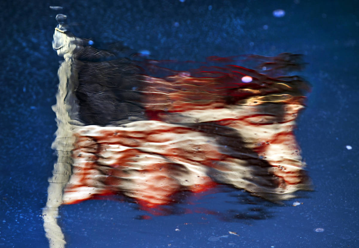 An American flag is reflected in a pool at New-York New-York along Las Vegas Boulevard on the S ...