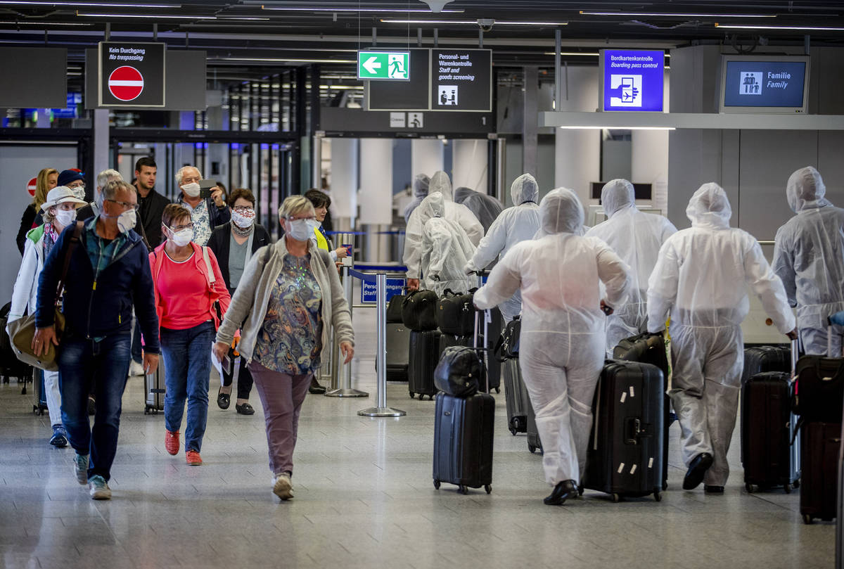 Passengers, left, who just arrived at the airport walk past crew members of South African Airwa ...