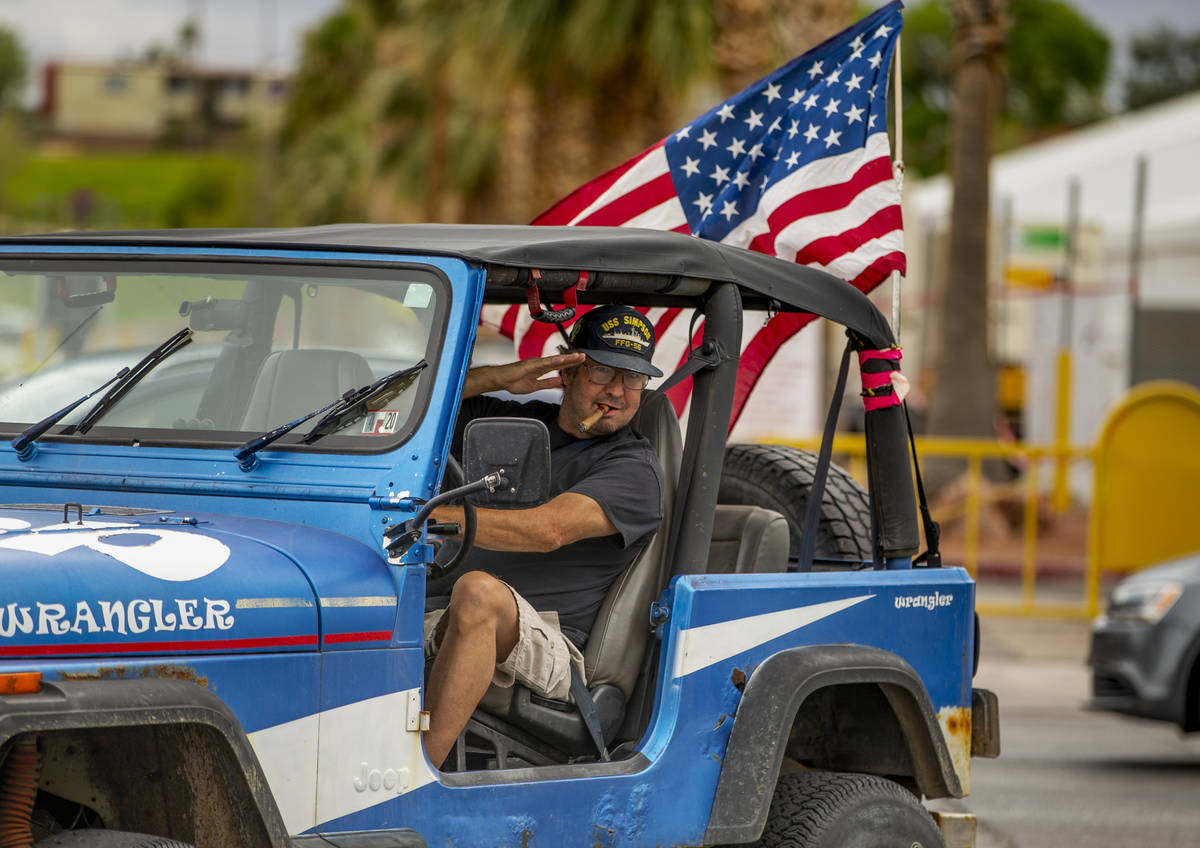 Greg Whalen salutes flag wavers as he follows others in for a protest at the Grant Sawyer State ...